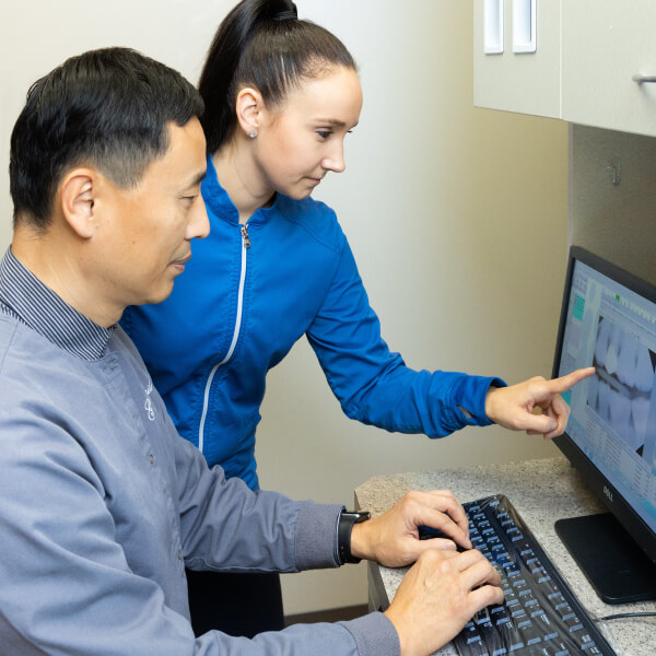 Dr. Charles Kim and dental assistant analyzing an x-ray