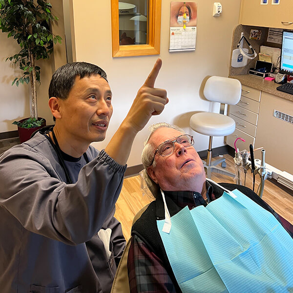 Dr. Charles Kim showing a senior male patient his x-ray exam