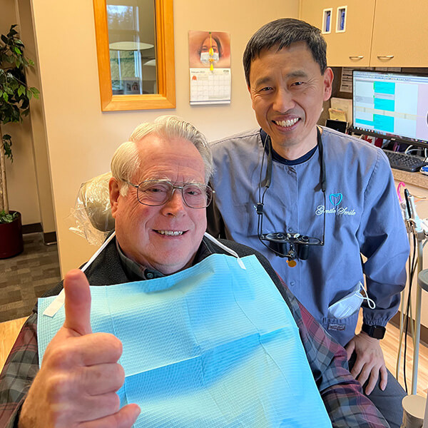 Dr. Charles Kim smiling right next to a senior male patient.